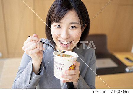 オフィスでカップ麺を食べる女性 73588667