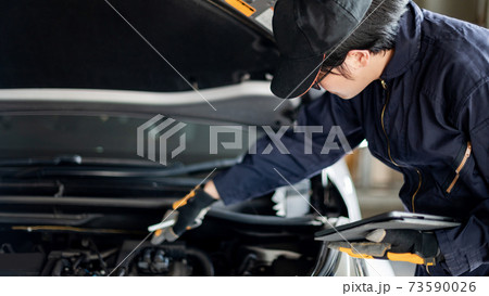 Asian auto mechanic checking the car using tablet Asian auto mechanic checking the car using tablet 73590026
