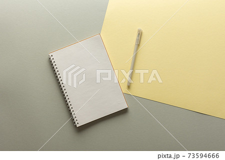 Open spiral notepad on gray and yellow background Open spiral notepad on gray and yellow background 73594666