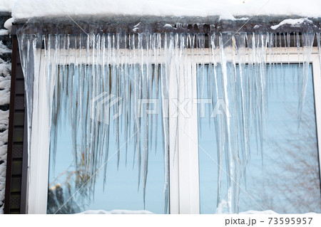 Icicles on the window of the house on a frosty day. 73595957