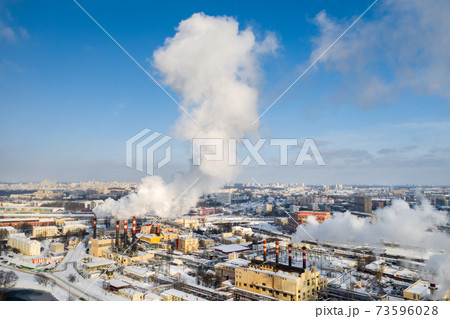 In the winter city, the factory's chimneys are smoking. The concept of air pollution. Environmental pollution by industrial waste In the winter city, the factory's chimneys are smoking. The concept of air pollution. Environmental pollution by industrial waste 73596028