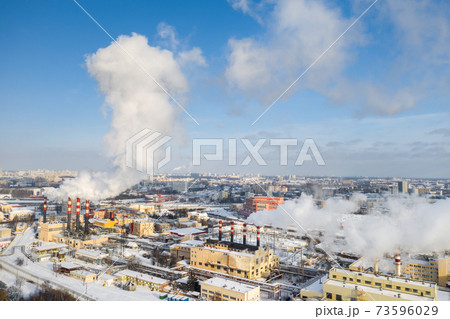 In the winter city, the factory's chimneys are smoking. The concept of air pollution. Environmental pollution by industrial waste 73596029