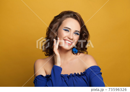 Lovely woman fashion model smiling on yellow background Lovely woman fashion model smiling on yellow background 73596326