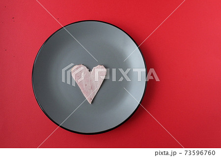 Still life breakfast for Valentine's Day Heart of ham sausage on a gray plate on a red bright background with a copy of the space Still life breakfast for Valentine's Day Heart of ham sausage on a gray plate on a red bright background with a copy of the space 73596760