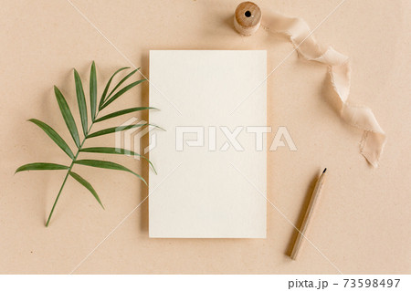 Mockup invitation, blank greeting card and tropical palm leaves. Flat lay, top view. Mockup invitation, blank greeting card and tropical palm leaves. Flat lay, top view. 73598497