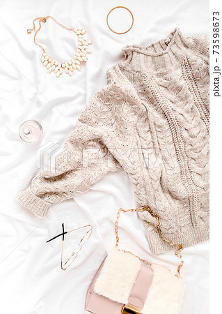 Woman clothes and accessories set on white background. Women's warm sweater, bag, glasses. Shopping concept. Flat lay, top view.  73598673