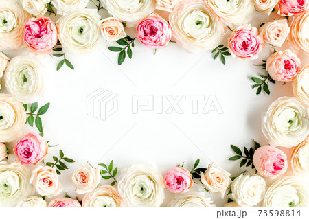 Floral pattern frame made of pink ranunculus and roses flower buds on white background. Flat lay, top view floral background. 73598814
