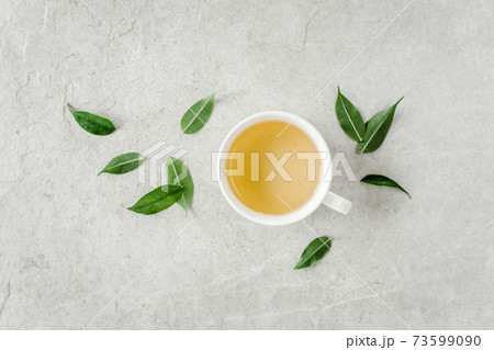 Cup of fresh green tea with tea leaves. Flat lay, top view. Tea concept Cup of fresh green tea with tea leaves. Flat lay, top view. Tea concept 73599090
