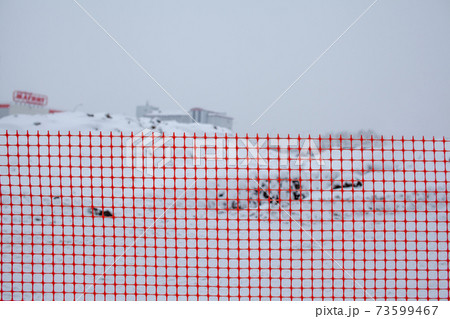 Plastic red safety net for construction site. Fencing repair work Plastic red safety net for construction site. Fencing repair work 73599467