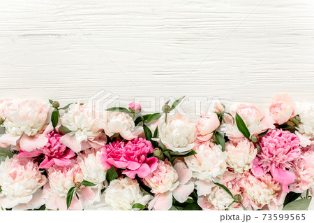 Floral frame wreath made of pink and beige peonies flower buds, eucalyptus branches and leaves isolated on white wooden background. Flat lay, top view 73599565