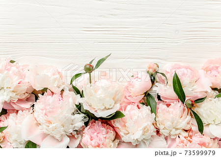 Floral frame wreath made of pink and beige peonies flower buds, eucalyptus branches and leaves isolated on white wooden background. Flat lay, top view 73599979
