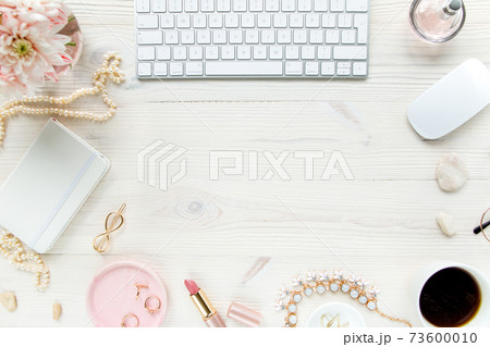 Top view office desk. Workspace with, computer, chrysanthemum, clipboard. Women's fashion accessories isolated on white wooden background. Flat lay Top view office desk. Workspace with, computer, chrysanthemum, clipboard. Women's fashion accessories isolated on white wooden background. Flat lay 73600010