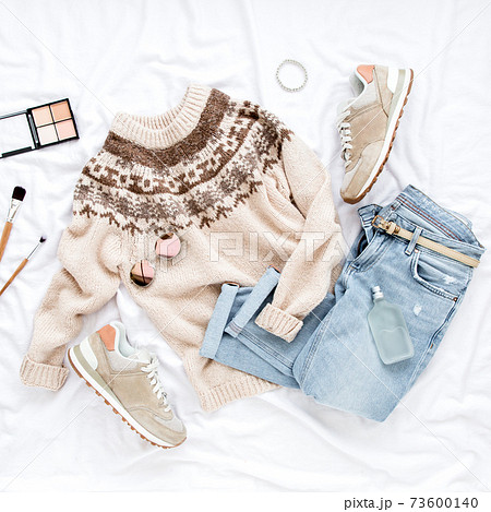 Female fashion look with stylish clothes and accessories. Women's warm sweater, jeans, sneakers. Modern and casual outfit. Flat lay, top view. 73600140