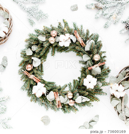 Wreath frame and wreath from vine and eucalyptus branch on white background. Flat lay, top view holiday decoration concept. Christmas composition. Wreath frame and wreath from vine and eucalyptus branch on white background. Flat lay, top view holiday decoration concept. Christmas composition. 73600169