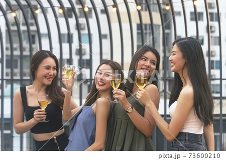 asian woman teenagers cheering and toast with white sparkling wine glass to celebrating at dinner party in summertime. celebration, relationship and friendship concept. asian woman teenagers cheering and toast with white sparkling wine glass to celebrating at dinner party in summertime. celebration, relationship and friendship concept. 73600210