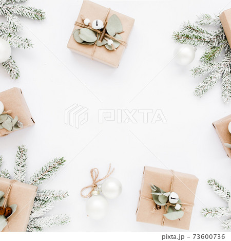 Christmas frame, pattern made in of craft boxes and green branches in the snow. Holiday and celebration concept. Top view. Flat lay Christmas frame, pattern made in of craft boxes and green branches in the snow. Holiday and celebration concept. Top view. Flat lay 73600736