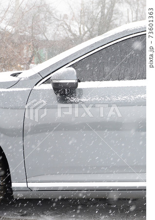 Fragment of the car under a layer of snow after a heavy snowfall. The body of the car is covered with white snow 73601363