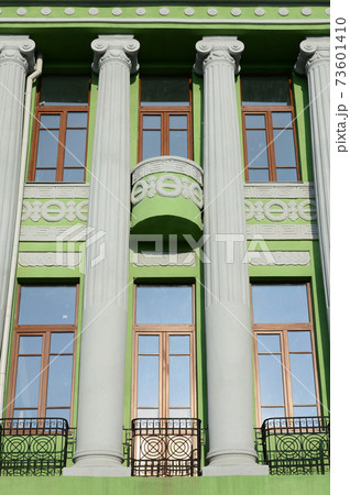 Restored old multi-storey building with antique columns, painted in green Restored old multi-storey building with antique columns, painted in green 73601410