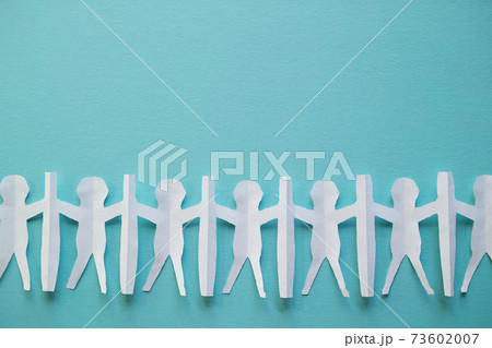 新型コロナ対策で衝立を挟んで繋がる人々の切り紙。青い背景とコピースペース。 73602007