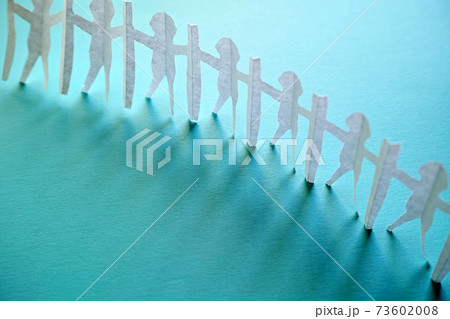 新型コロナ対策で衝立を挟んで繋がる人々の切り紙。青い背景とコピースペース。 73602008