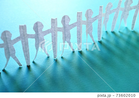 新型コロナ対策で衝立を挟んで繋がる人々の切り紙。青い背景とコピースペース。 73602010
