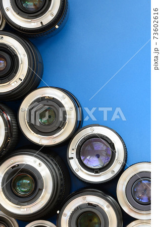 Several photographic lenses lie on a bright blue background. Space for text Several photographic lenses lie on a bright blue background. Space for text 73602616