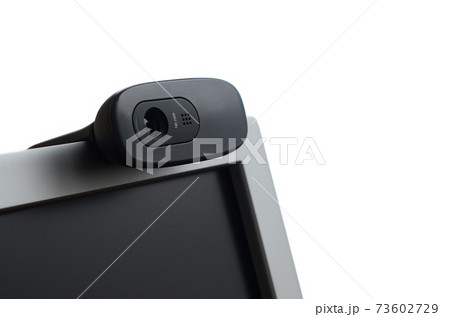 A modern web camera is installed on the body of a flat screen monitor. Device for video communication and recording of high quality video 73602729