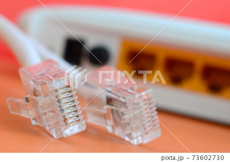 Internet router and Internet cable plugs lie on a bright orange background. Items required for Internet connection Internet router and Internet cable plugs lie on a bright orange background. Items required for Internet connection 73602730