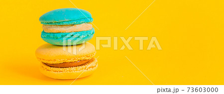 Sweet almond colorful unicorn blue yellow macaron or macaroon dessert cake isolated on trendy yellow modern fashion background. French sweet cookie. Minimal food bakery concept Copy space Sweet almond colorful unicorn blue yellow macaron or macaroon dessert cake isolated on trendy yellow modern fashion background. French sweet cookie. Minimal food bakery concept Copy space 73603000