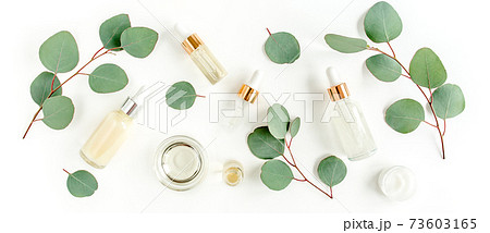Eucalyptus essential oil, eucalyptus leaves on white background. Natural, Organic cosmetics products. Medicinal, Natural Serums. Flat lay, top view. Eucalyptus essential oil, eucalyptus leaves on white background. Natural, Organic cosmetics products. Medicinal, Natural Serums. Flat lay, top view. 73603165
