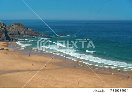 Delightful panoramic view of the Portuguese beach Odeceixe with tourists at the sea. 73603994