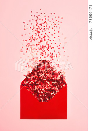 Red confetti scattered from envelope on pink background. Red confetti scattered from envelope on pink background. 73606475