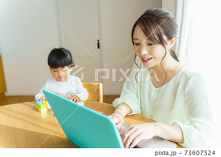 パソコンで作業をするママ 73607524