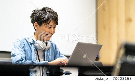 動画・映像クリエイター 男性　ヘッドホン　ノートパソコン 73608168