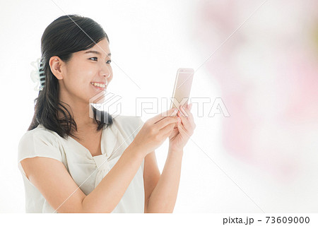 スマホを操作する女性 春のイメージ スマホを操作する女性 春のイメージ 73609000