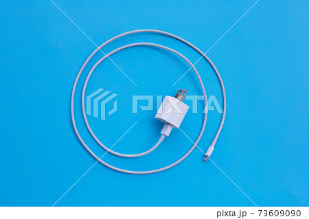 Mobile phone charger on blue background. Mobile phone charger on blue background. 73609090