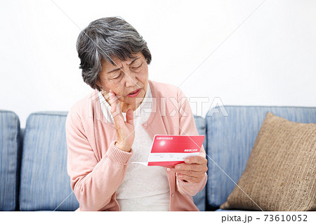 預金通帳を確認するシニア女性 預金通帳を確認するシニア女性 73610052