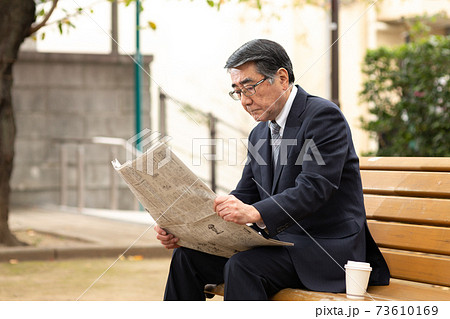ベンチに座って新聞を読むシニア男性 ベンチに座って新聞を読むシニア男性 73610169