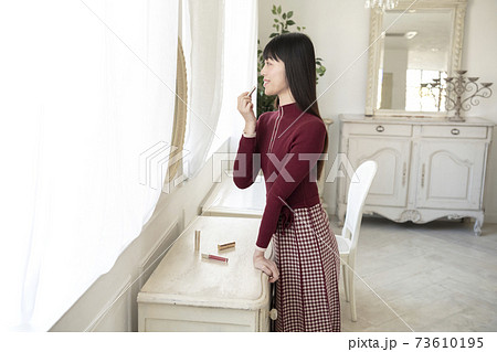 鏡を見てルージュ(口紅)を塗る女性 鏡を見てルージュ(口紅)を塗る女性 73610195