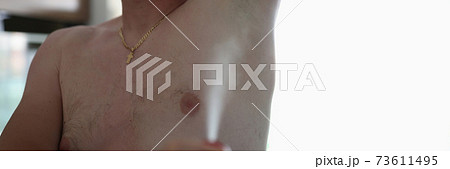 Man sprays antiperspirant deodorant on armpit 73611495