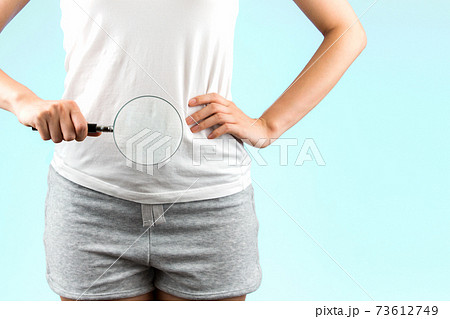 woman looks at her crotch with a magnifying glass Stock Photo