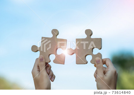 Woman hands connecting couple puzzle piece against sunrise effect, businesswoman holding wood jigsaw with sunset background. Business solutions, target, success, goals and strategy concepts Woman hands connecting couple puzzle piece against sunrise effect, businesswoman holding wood jigsaw with sunset background. Business solutions, target, success, goals and strategy concepts 73614840