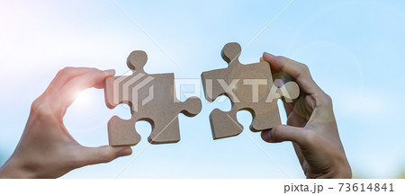 Woman hands connecting couple puzzle piece against sunrise effect, businesswoman holding wood jigsaw with sunset background. Business solutions, target, success, goals and strategy concepts Woman hands connecting couple puzzle piece against sunrise effect, businesswoman holding wood jigsaw with sunset background. Business solutions, target, success, goals and strategy concepts 73614841