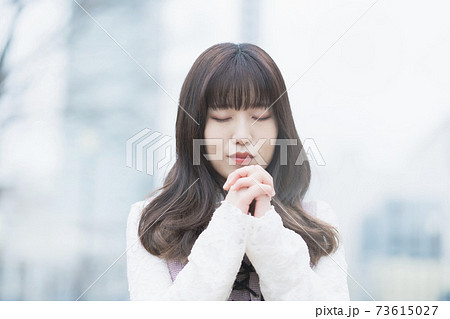 お祈りのポーズをする女性の写真素材