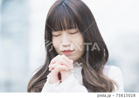 お祈りのポーズをする女性の写真素材
