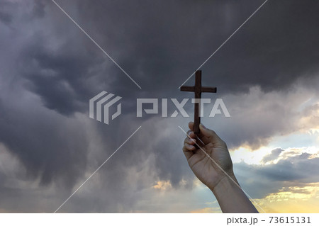 Silhouette hand holding wood cross against sunrise background, open palm up worship, pray for blessings from God. Christian Religion, Crucifix and Faith concept Silhouette hand holding wood cross against sunrise background, open palm up worship, pray for blessings from God. Christian Religion, Crucifix and Faith concept 73615131