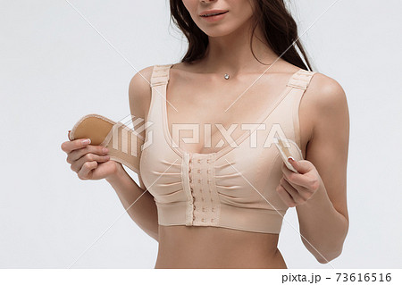Young woman in beige bra on white background 73616516
