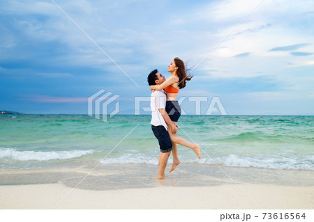 couple picking up and hugging on the sea beach at Koh MunNork Island, Rayong, Thailand 73616564