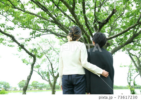 卒業式後に木を見上げる親子 73617230