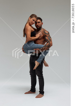 Woman hugging muscular man from behind 73618055